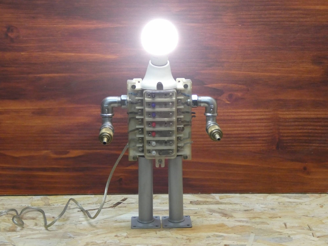 Escultura lámpara robot realizada con material reciclado, antiguo conector eléctrico y piezas de fontanería y aire comprimido. MEDIDAS: Ancho 43 cm X Alto 23 cm 