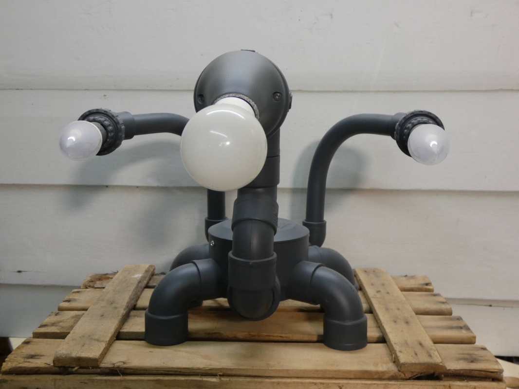 Escultura lámpara robot realizada con PVC , piezas de fontanería y electricidad , línea  robot terminator futurista efecto gris grafito. MEDIDAS: Ancho 40 cm X Alto 31 cm X Fondo 41 Bombillas incluidas