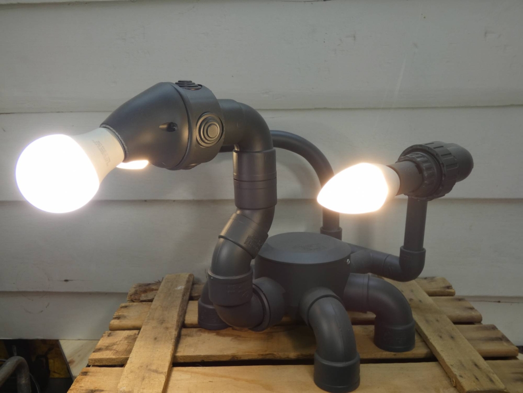 Escultura lámpara robot realizada con PVC , piezas de fontanería y electricidad , línea  robot terminator futurista efecto gris grafito. MEDIDAS: Ancho 40 cm X Alto 31 cm X Fondo 41 Bombillas incluidas