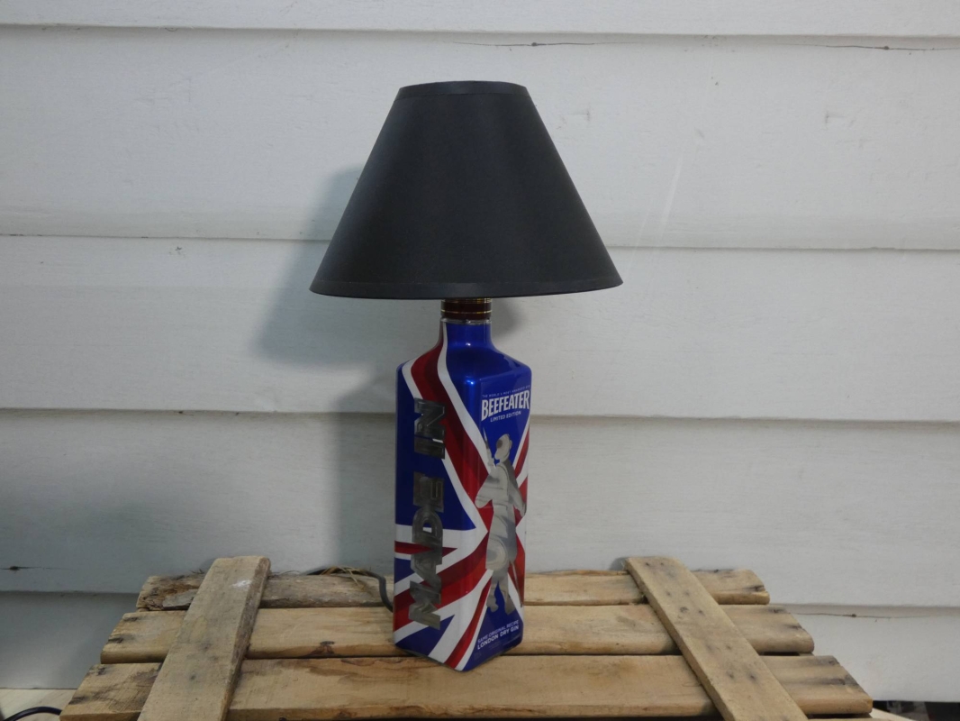 Lámpara realizada con botella reciclada de beefeater edición limitada, con pantalla redonda en color negro. MEDIDAS:  Ancho 20 cm X Alto 38 cm X Fondo 20 cm