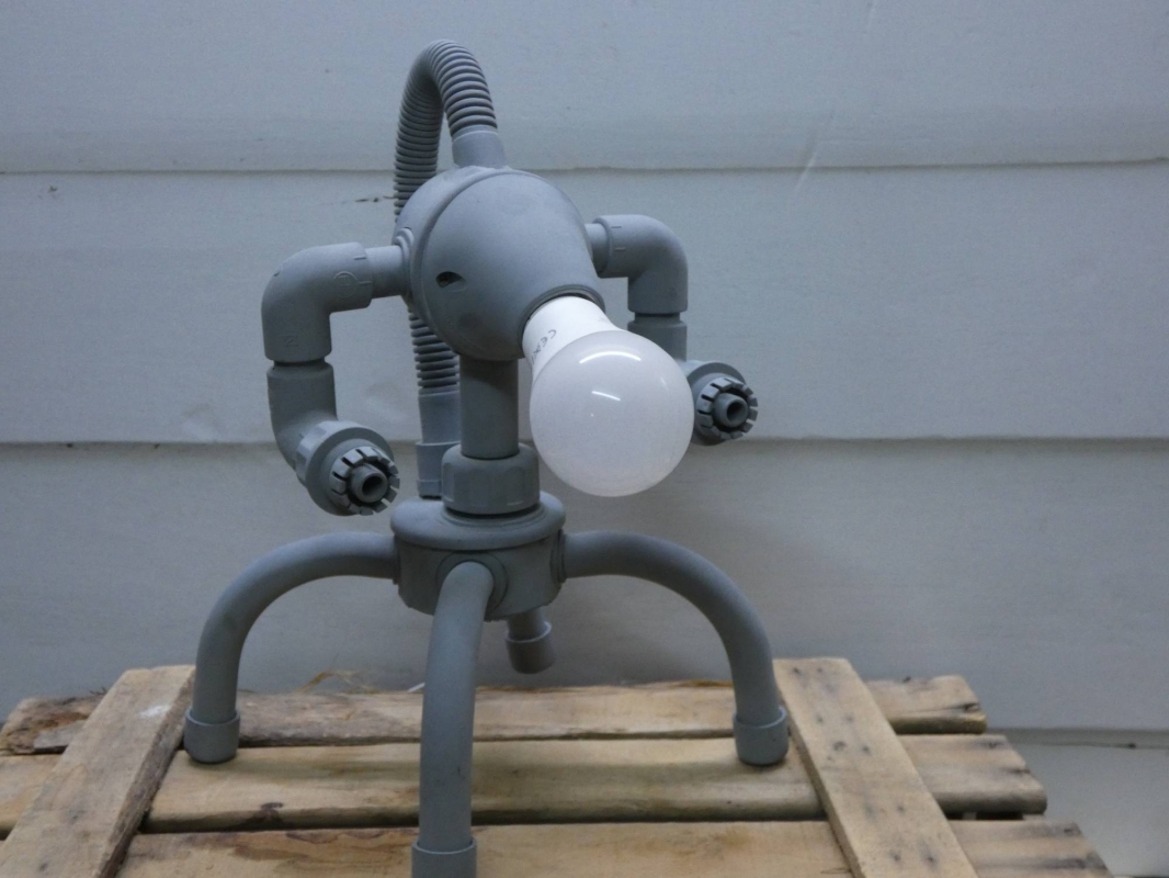 Escultura lámpara robot realizada con PVC, piezas de fontanería y electricidad, línea robot terminator  futurista efecto oxido. MEDIDAS: Ancho 25 cm X Alto 33 cm X Fondo 21 cm Bombilla incluida